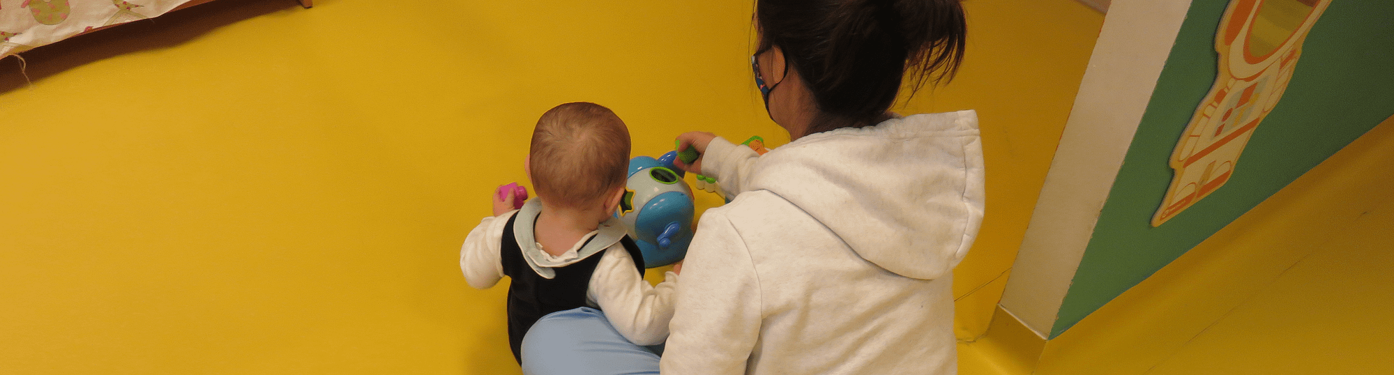 Une puericultrice joue avec un bébé