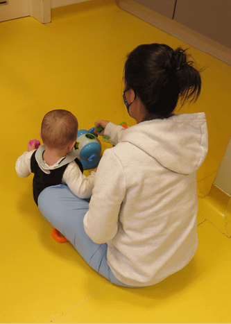 Une puericultrice joue avec un bébé